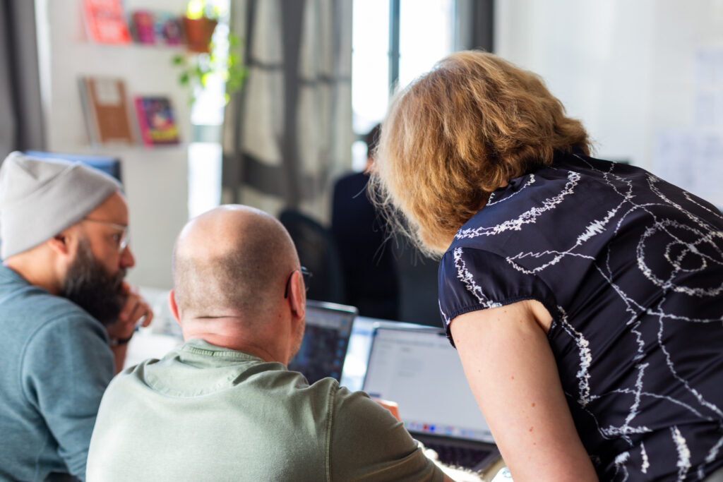 Claudia schaut während eines Workshops über die Schulter von zwei Teilnehmern