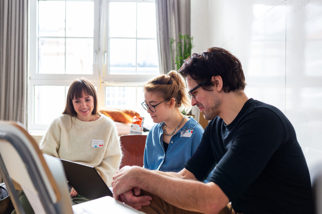 Drei Personen während des Workshops vor Laptop