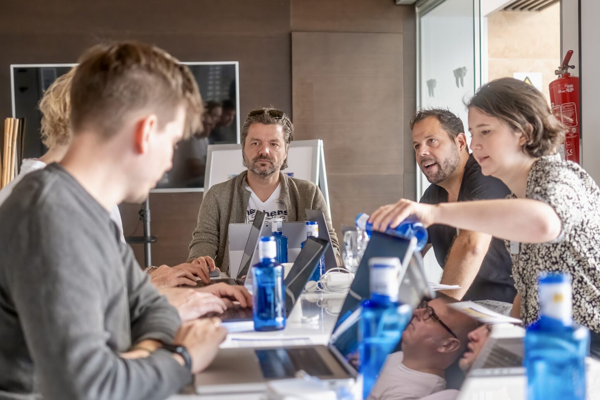 Mehrere Personen in Workshop Situation vor Laptops